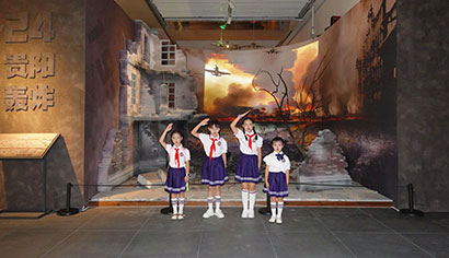 5173-3-5参加展览开幕表演的学生们在“24贵阳轰炸”展墙前敬礼。.jpg